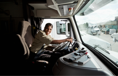 black woman at the wheel in the cab of a semi truck