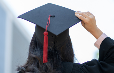 Girl facing away from camera in graduation cap and gown, transerivce 2024 scholarship awardees