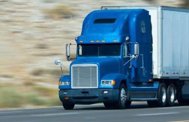 blue semi truck pulling white trailer down road, busting trucking myths