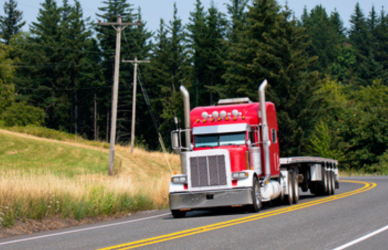 red peterbilt semi truck on tree-lined road, Peterbilt renews its commitment to future trucking leaders by sponsoring the ATA Trucking U program for the second year.