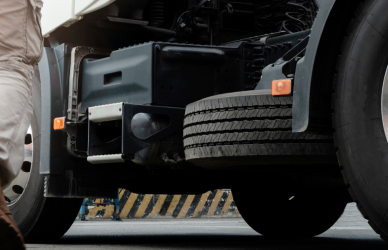 man in work boots walking toward semi truck in sunlight. unforgettable first-day stories of truck drivers across America