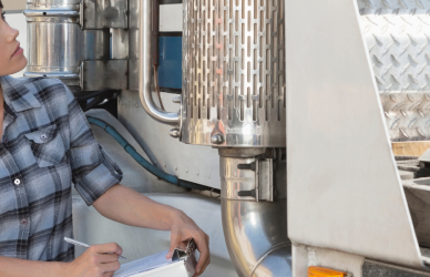 woman with clipboard next to semi truck