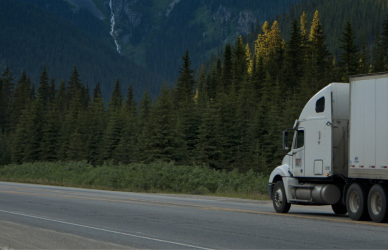 semi truck driving on road through mountains