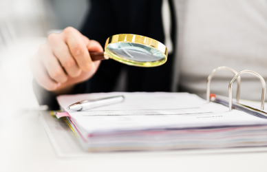 magnifying glass looking over paperwork