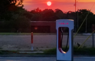 tesla charger with sunset in background