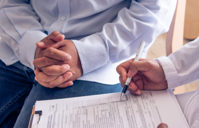 doctor filling out form with patient