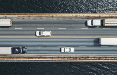 cars and trucks on bridge over water