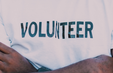 black man in volunteer shirt with crossed arms
