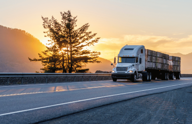 semi driving down a mountain highway at sunset