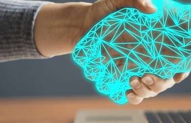 Human hand shaking hands with artificial hand coming out of computer