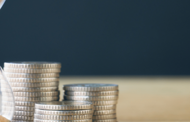 coins on table next to hourglass