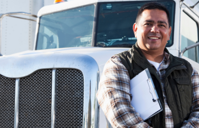 man with clipboard standing in front of semi truck