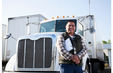 man holding clipboard standing in front of semi truck