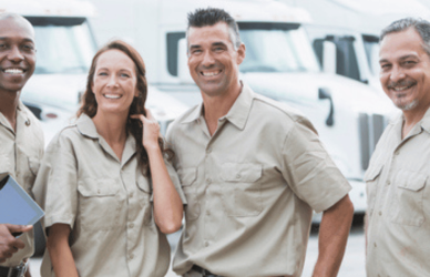 diverse group of people standing in front of semi trucks