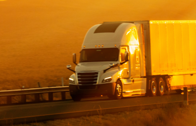 semi truck driving at sunset