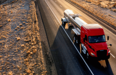 Tanker truck on highway with mountains in background
