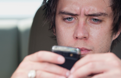 man looking at phone while driving