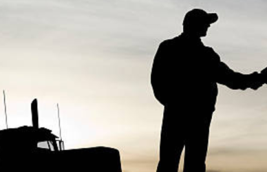 silhouettes of two men shaking hands next to a semi truck