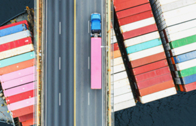 Semi truck on bridge over freight barge