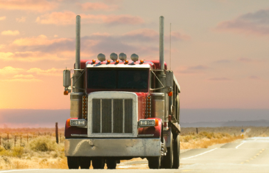 semi truck on road at sunset