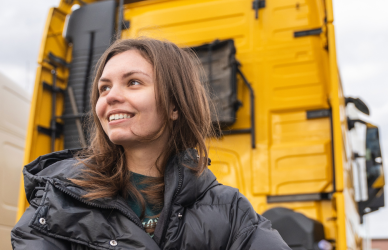 Woman standing in front of semi trucks