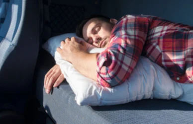 Man sleeping in semi truck cab