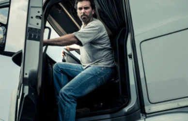 Truck driver getting out of semi truck cab