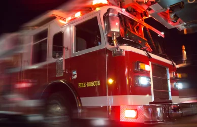 Fire truck with lights on driving down the road